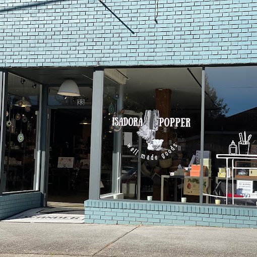 Storefront for Isadora Popper, a handmade goods shop, with large glass windows and visible merchandise inside. - Clayton, GA