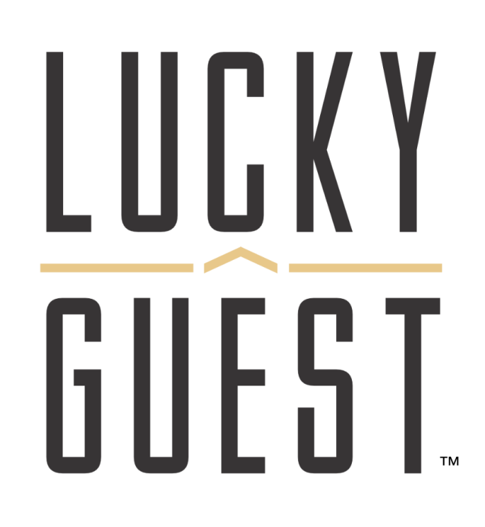 Lucky Guest Lucky Guest logo: tall black letters spell 'LUCKY' above 'GUEST' with a beige chevron between and beige lines on either side. - Clayton, GA