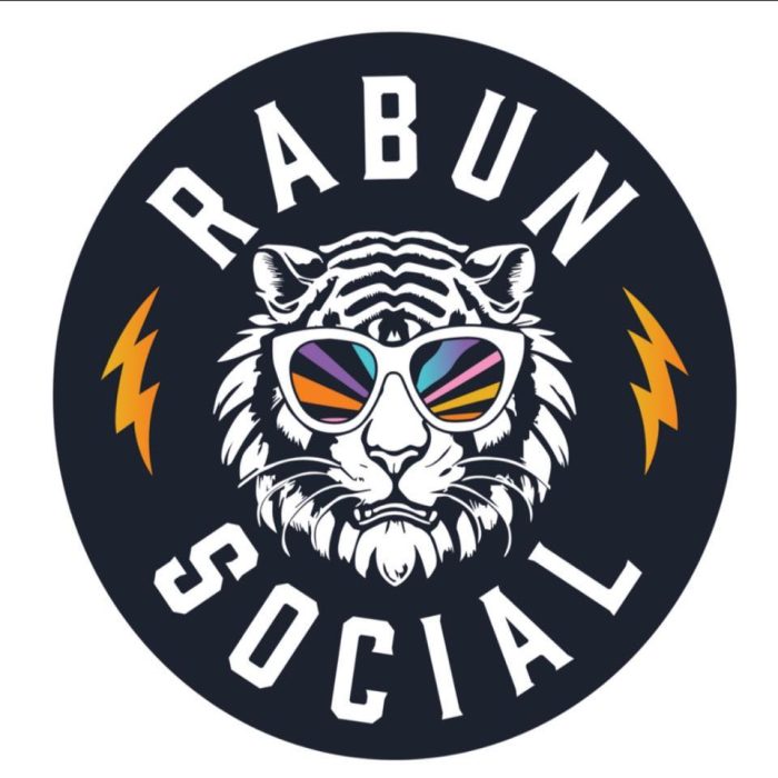 Circular logo: white tiger with colorful sunglasses in a dark circle, orange lightning bolts on sides, 'RABUN SOCIAL' around the edge. - Clayton, GA