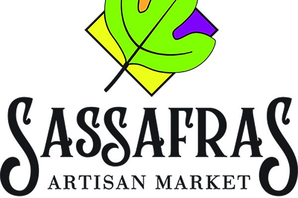 Logo for Sassafras Artisan Market featuring a green leaf over a multicolored diamond, with the text “Sassafras Artisan Market” and “The North Georgia Arts Guild.” - Clayton, GA