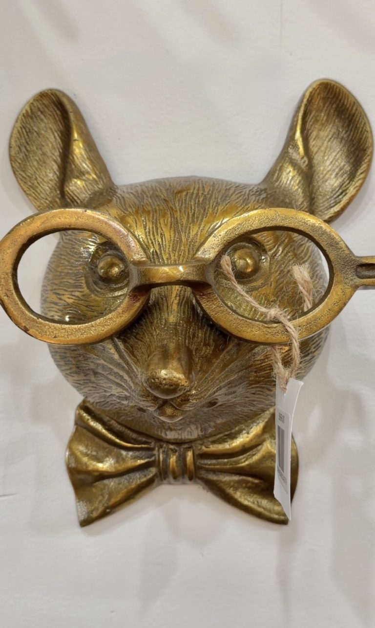 Gold-toned dog bust wearing oversized round glasses and a bow tie (decorative statue).