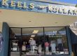 Storefront of Keels & Kollars clothing shop with large sign, glass display window showing mannequined outfits and a patriotic display outside in Clayton, Georgia.